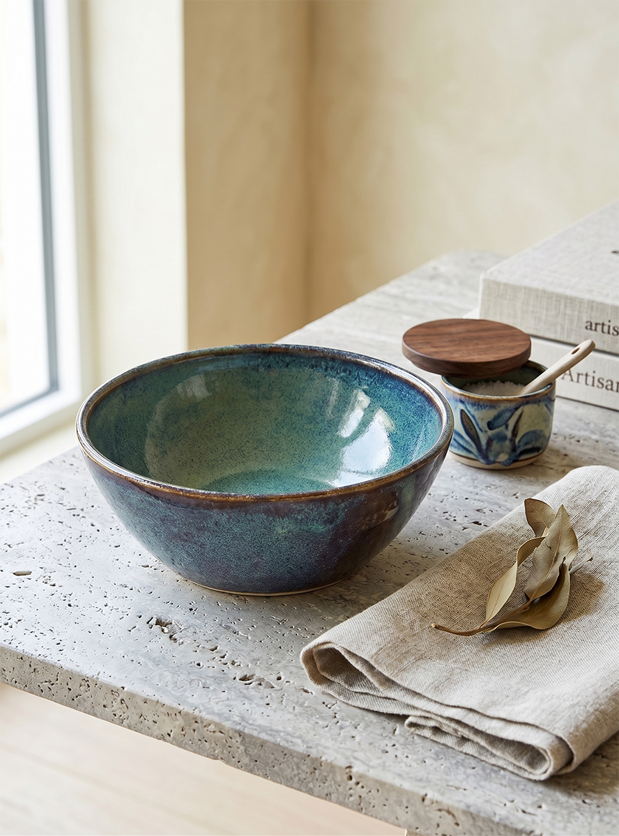 Deep teal glazed breakfast bowl on a travertine surface