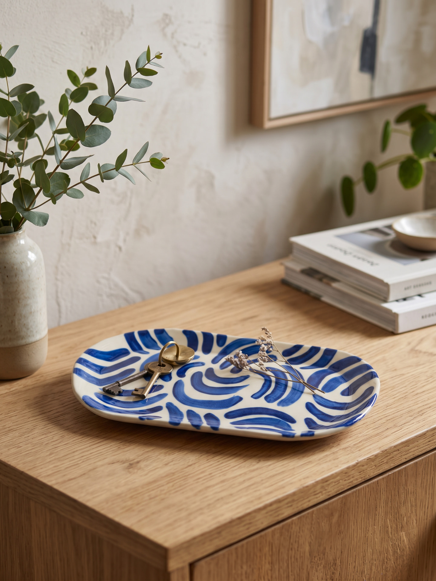 Shallow tray with cobalt blue brushstrokes on an oak console